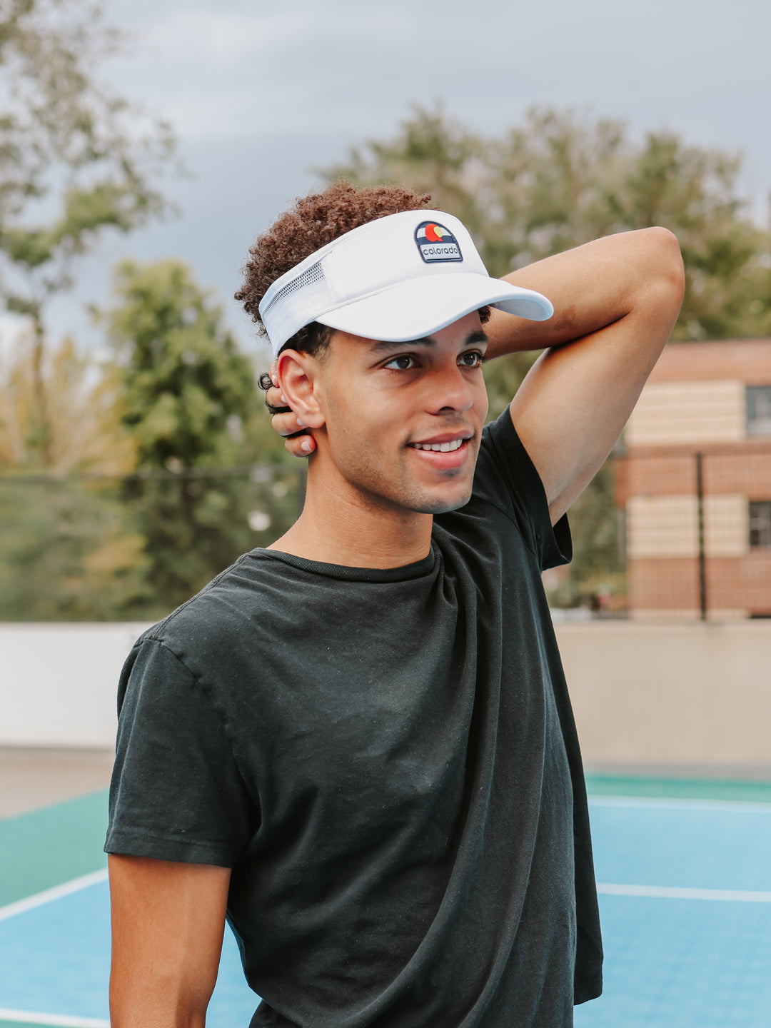 Man wearing white CO Love Colorado flag trucker visor on tennis court — Bear & Sarge
